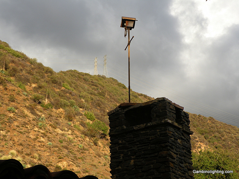 A light source is concealed inside of a bird house manufactured by Nightingale and installed high above his property at the top of the chimney of what was his design studio and manufacturing shop.